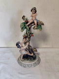 Statuina Decorativa con Putti su Albero in Porcellana Policroma